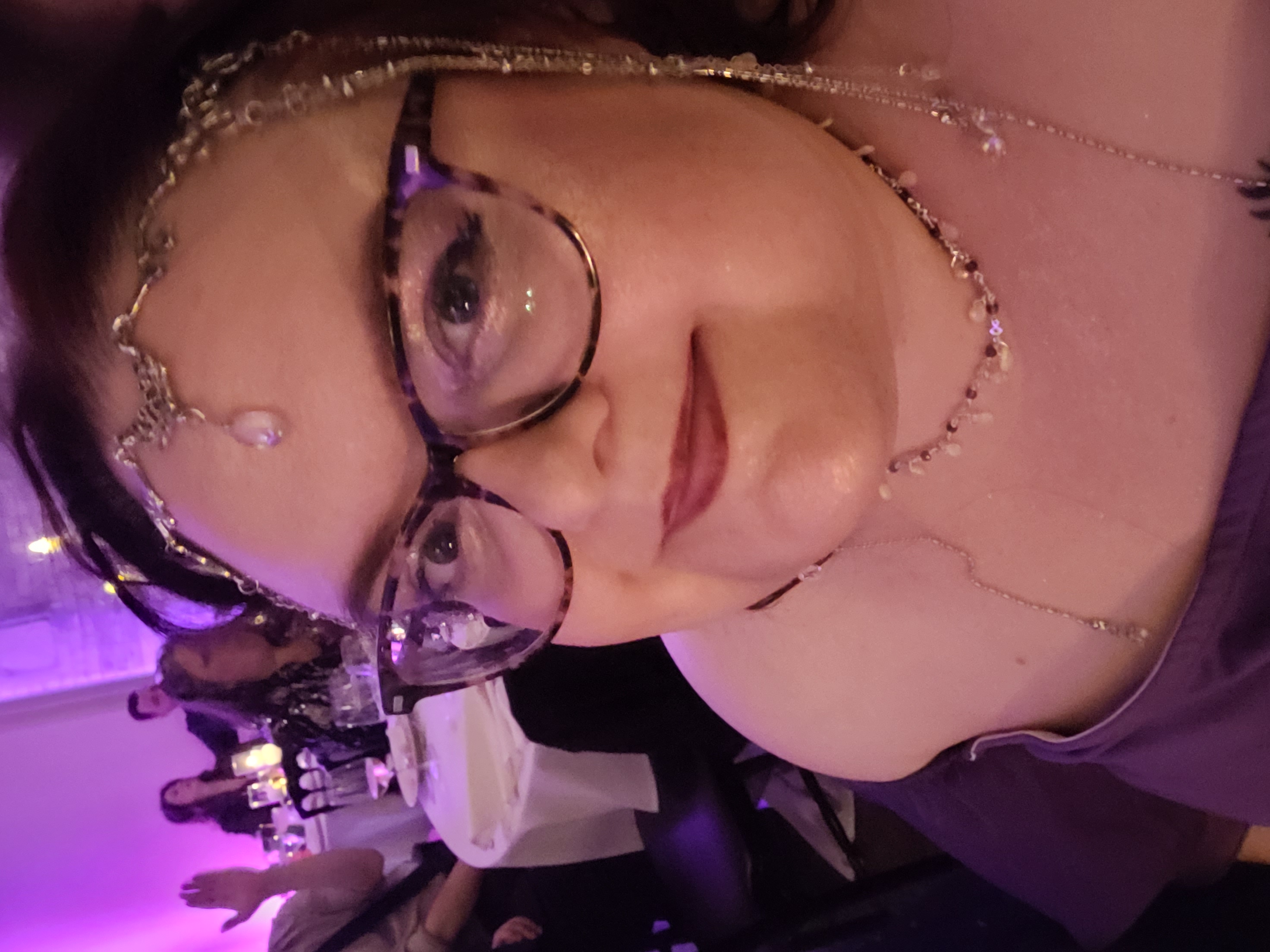 Photo of a woman with dark hair, large glasses, and a round face